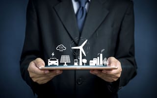 Person holds up a tablet with energy figures.