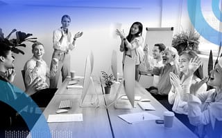 Happy employees applauding a colleague in an office.