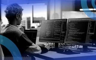 Engineer coding on dual monitors