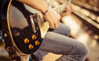 A person is shown playing a guitar.