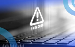 A close-up of a laptop keyboard with a 3D image of an exclamation point inside a triangle and the word “breached” in all caps underneath.