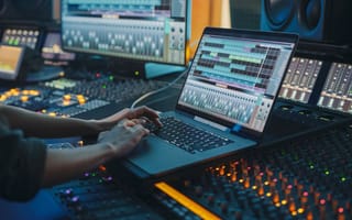 Audio engineer edit a clip on laptop.