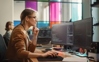Tech worker works on computer.