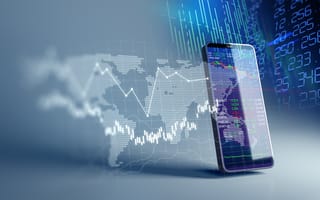 A smartphone with investment information on it, and more investment information surrounding it