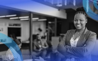 A smiling and successful Black woman in a workspace.