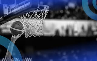 A close-up of someone dunking a basketball in a basketball hoop.