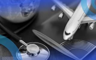 A miniature airplane on a passport next to a stethoscope and mini globe.