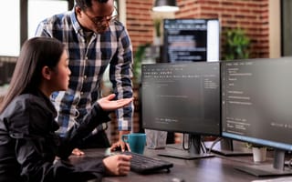 Tech employs work on code in an office.