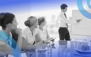 A man gives a presentation to his coworkers at a whiteboard