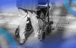 An elderly person using a walker with wheels on a cut curb.