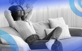 A woman recinling happily on a couch.