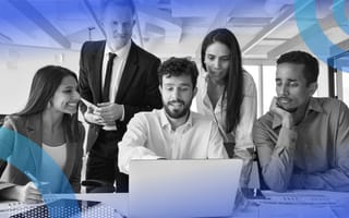 Five coworkers crowded around a laptop looking at the screen with varying levels of interest.