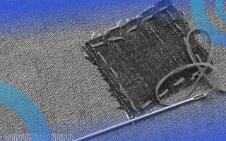 A patch of fabric stitched onto denim with the needle still attached.