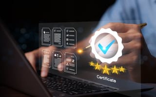 Photograph of a person at a laptop, with a graphic of certification and a checkmark on overlayed top