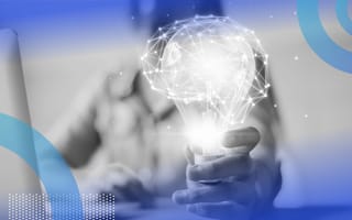 A hand is holding a lightbulb that is glowing in the shape of a brain.