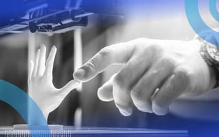 A close-up of a hand touching a minuature 3D printed hand.