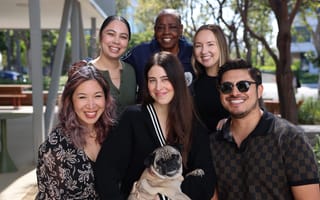 GoodRx smiling, posing for group photo on an outdoor patio, with one employee holding a dog in their arms