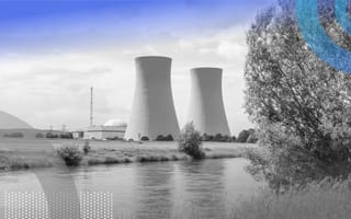 A pair of nuclear reactors are on the banks of a river.