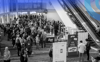 Hundreds of people are walking around at a tech conference.