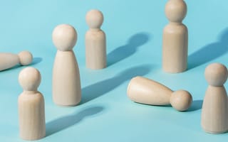 Wooden figurines are pictured against a blue background.