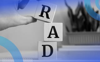 A close-up of someone stacking blocks on top of each other that spell RAD.