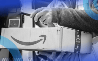 A delivery person is holding an Amazon package.