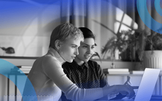 Two women leaders are sitting at a computer and talking.
