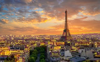 Skyline of Paris at sunset with Eiffel Tower visible.