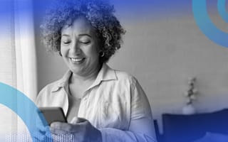 A woman smiling at her smart phone.