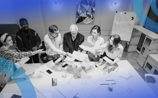 A multigenerational team is sitting around a table working on a project.