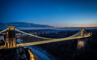 The famous Clifton Suspension Bridge over a river in Bristol, Southwestern England during sunset