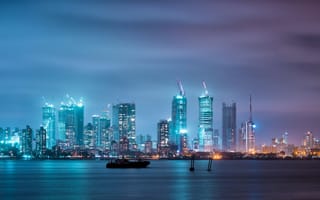 The Mumbai skyline aglow with the lights of the city on a dusky night.