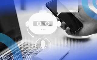 A closeup on someone holding a smartphone and working on a laptop with a chatbot icon