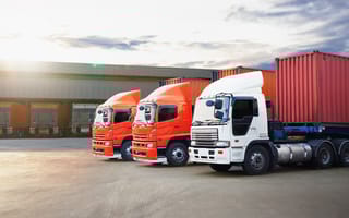 Three freight trucks are parked in a line.