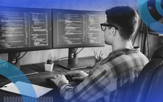 Developer coding in C++ on dual monitors