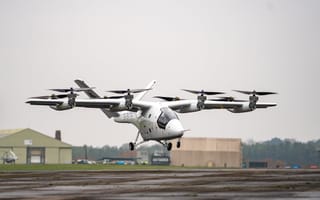 Electric aircraft pictured hovering over the ground.