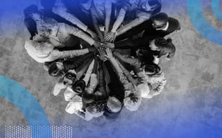 A diverse group of people put their hands in a circle