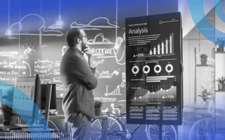 A marketer stands with a contemplative hand on his chin, staring at a big hologram displaying analytics.