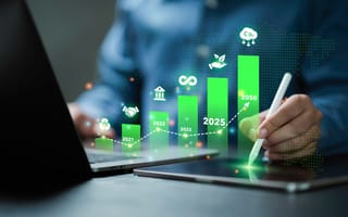 A digital illustration of a green bar graph hovers over a laptop and tablet device.
