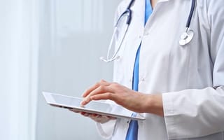 A doctor uses a tablet.