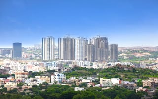 A skyline view of Hyderabad featuring skyscrapers and greenery.