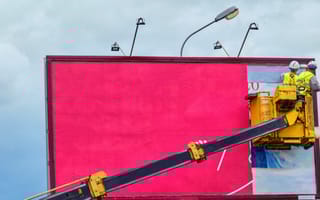 worker installing billboard