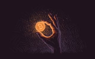 A hand holds up an orange Bitcoin that glows in the dark.