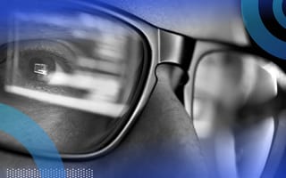 A closeup on the eyes of a developer wearing glasses and looking at code