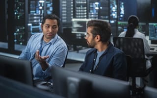 Two IT workers chat about code.