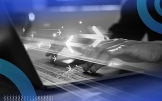 A laptop with data migrating and a closeup of someone typing on it