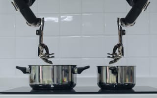 Two robot hands hover over two pots.