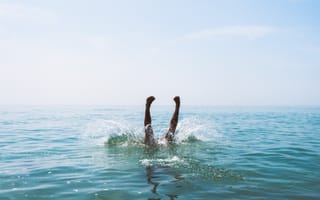 A person diving into a body of water.