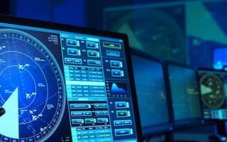 Air traffic control software is displayed across desktop computer monitors.