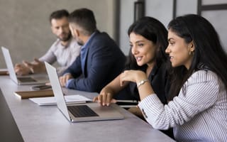 Four team members working on laptops together